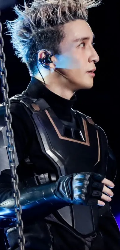 Performer in futuristic black armor with a vibrant backdrop.