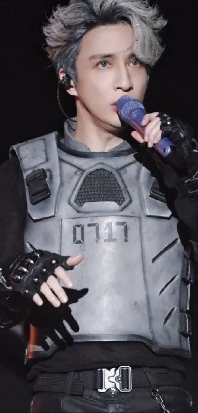 Futuristic performer with silver hair and modern outfit holding a microphone.