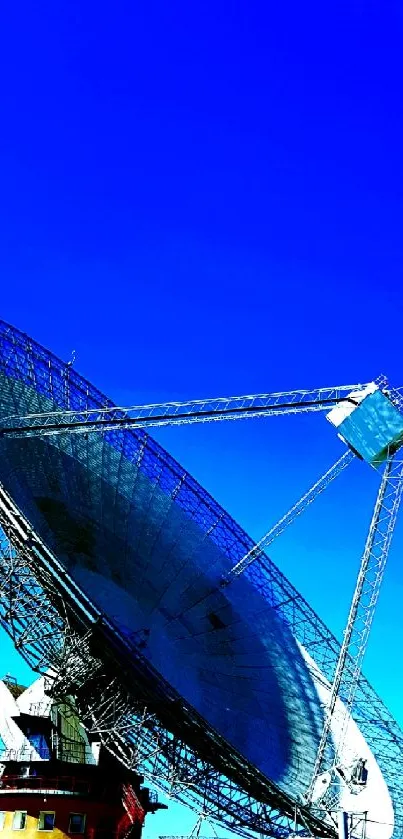 Satellite dish against vibrant blue sky.