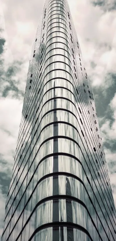 Futuristic skyscraper reaching into cloudy sky.