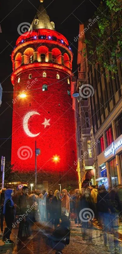 Galata Tower illuminated at night in Istanbul, surrounded by city life.