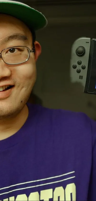 Gamer smiling with console in purple shirt.