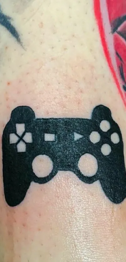 Black gaming controller tattoo on skin with a colorful background.