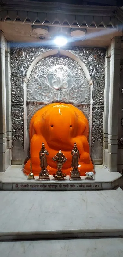 Ganesh temple with orange statue and intricate marble details.