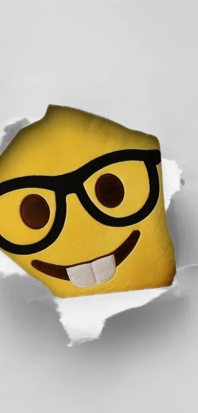 Geeky emoji with glasses breaking through white paper on a yellow background.