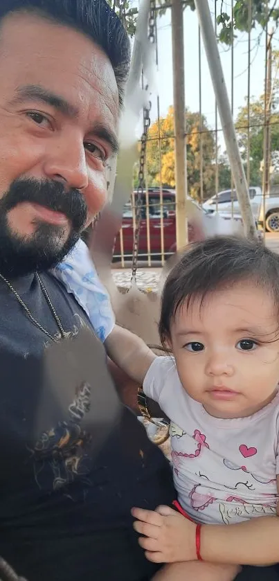 Father and child enjoying a day at the park on a swing.