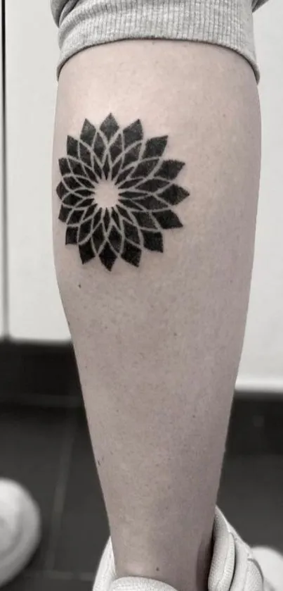 Geometric tattoo design on a calf in monochrome style.