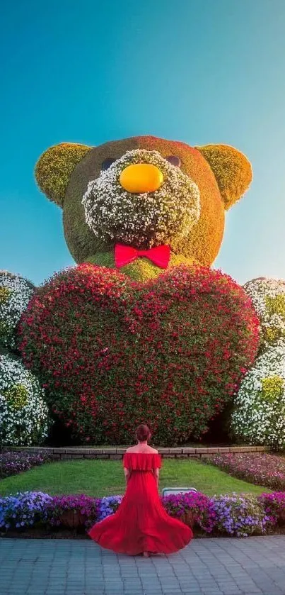 Giant teddy bear made of flowers with a heart in a garden setting.