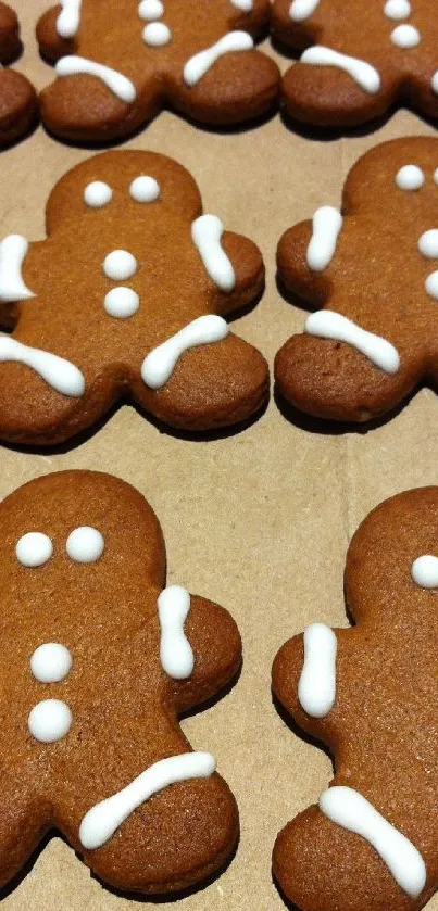 Rows of decorated gingerbread men with white icing on a brown background.