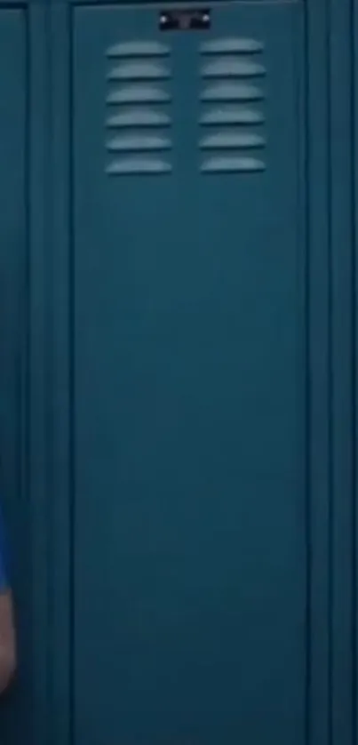 Girl sitting against teal lockers in peaceful setting.