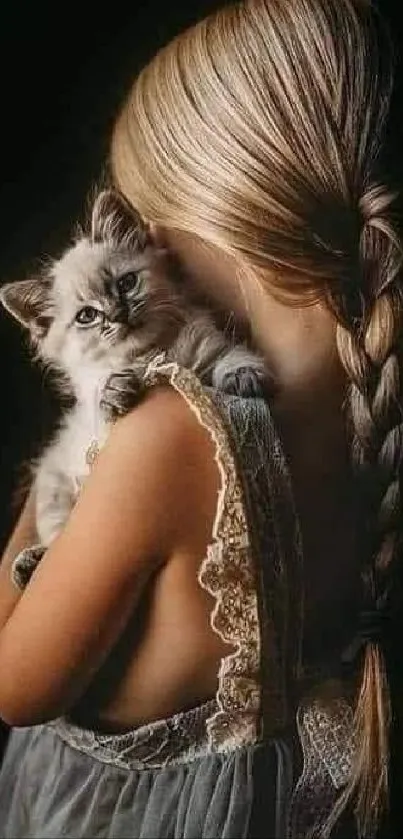 Girl with braided hair holds a fluffy kitten.