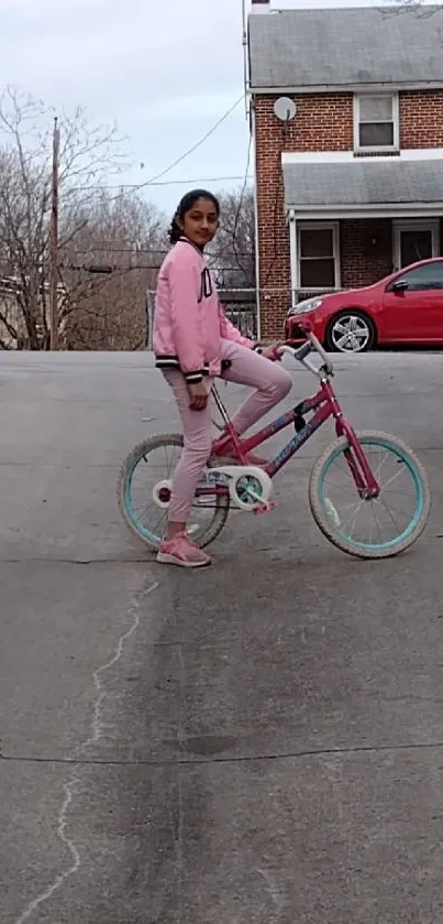 Girl riding a bicycle on a suburban street, surrounded by cars and houses.