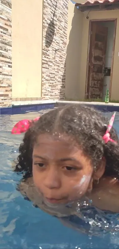 Child joyfully swimming in a clear, sunlit pool.