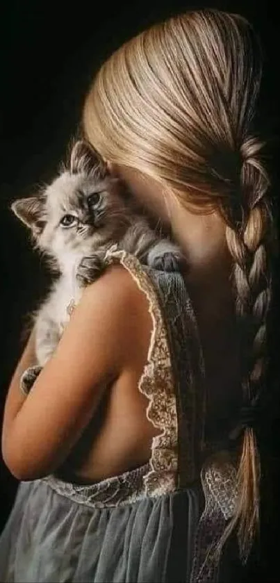 Wallpaper of girl holding a fluffy kitten against a dark backdrop.