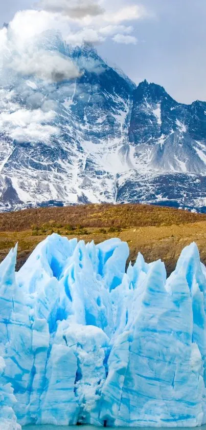 Glacial landscape with snowy mountains and ice blue glacier in the foreground.