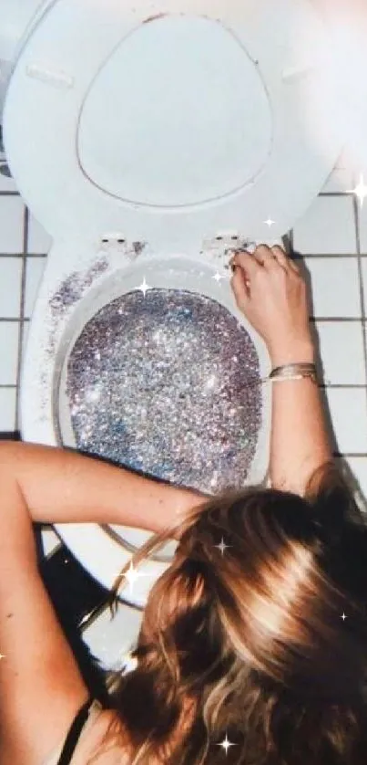 Hand on a glitter-filled toilet with tiled floor.