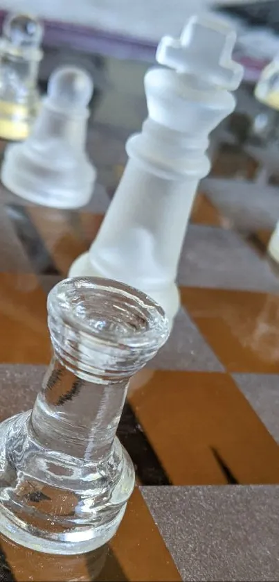 Glass chess pieces on a reflective brown and black board.