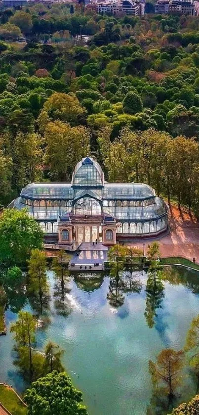 Aerial view of a glass palace in a green park with a reflecting pond.