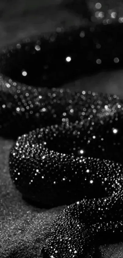 Glistening black snake on dark surface wallpaper.