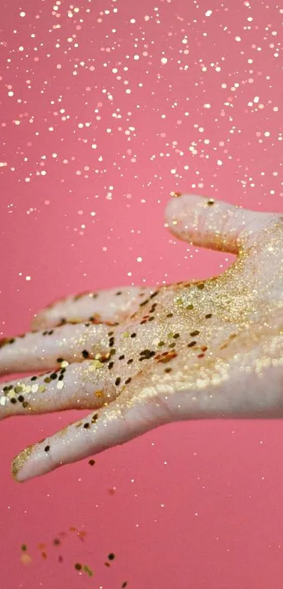 Hand covered in gold glitter with pink background wallpaper.