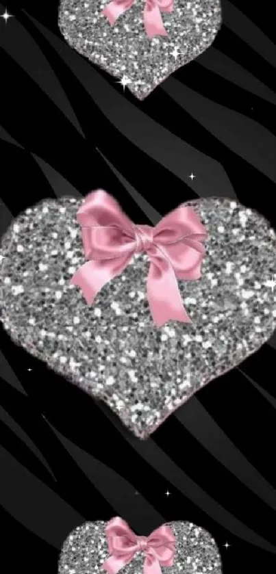 Silver glitter hearts with pink ribbons on zebra background.