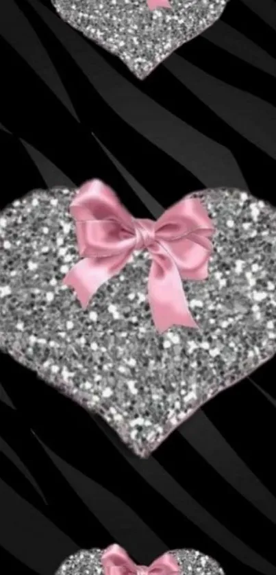 Silver glitter heart with pink ribbon on black wallpaper.