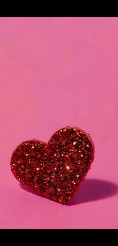 Red glitter heart on a pink background, ideal for phone wallpaper.