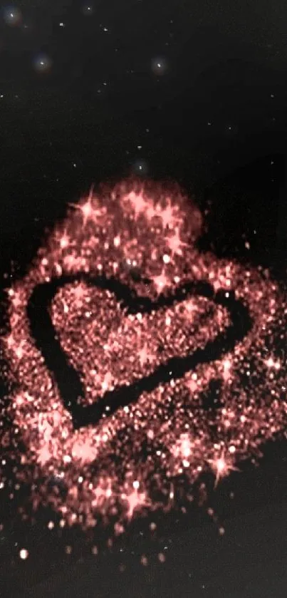 Heart made of pink glitter sparkles on a dark background.