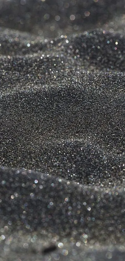 Glittering black sand close-up texture.