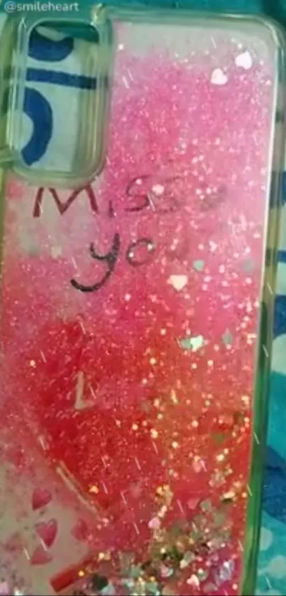 Pink glittery phone case with 'Miss you' message.