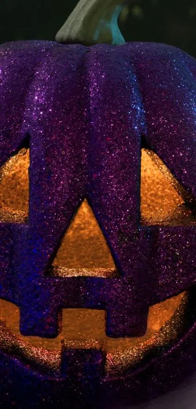 Vibrant purple glitter pumpkin with glowing carved face for Halloween.