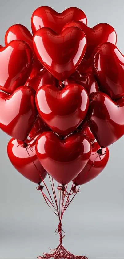 Glossy red heart balloons clustered together on a gray background.