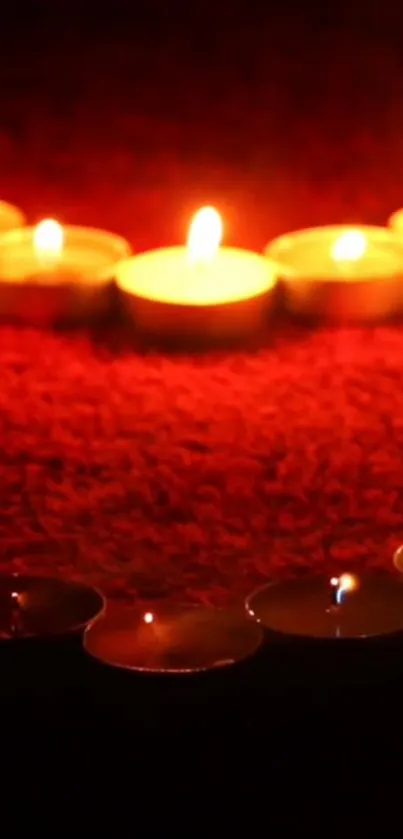 Mobile wallpaper with candles on a red background creating a warm, calming glow.