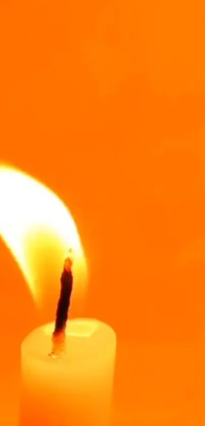 A glowing candle against an orange background.