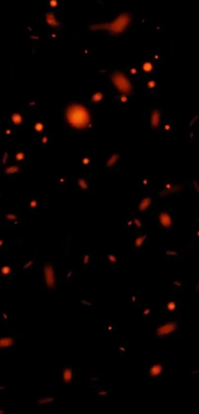 Glowing orange embers on a black background wallpaper.