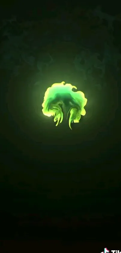 A glowing green jellyfish on dark green wallpaper.