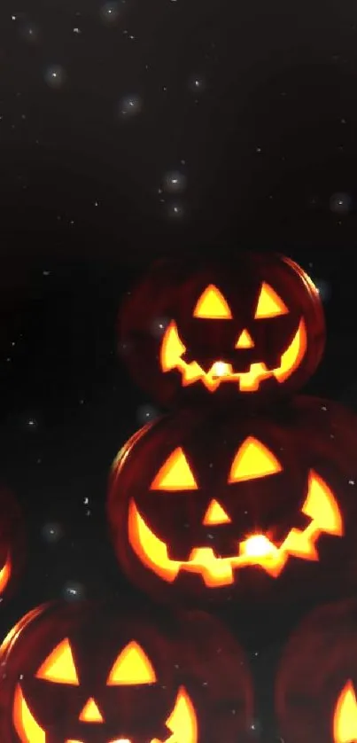 Glowing jack-o'-lanterns stacked on a dark background.