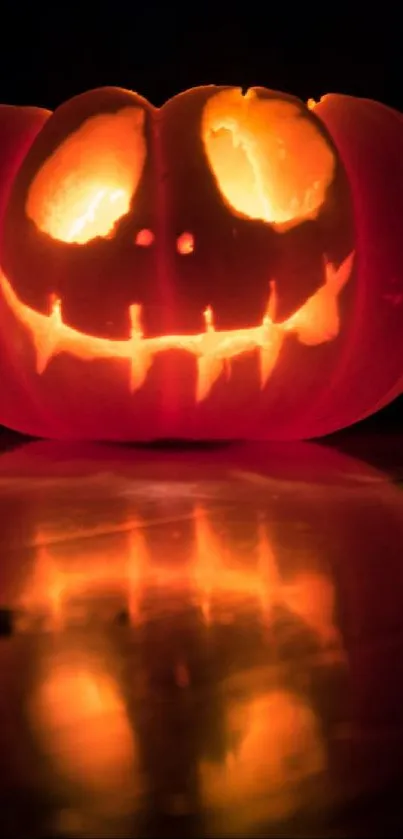 Spooky glowing Jack-O'-Lantern pumpkin with reflection.