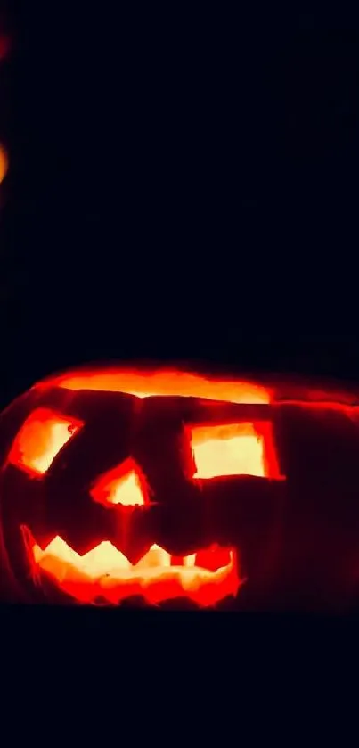 Glowing Halloween jack-o'-lantern on dark background.