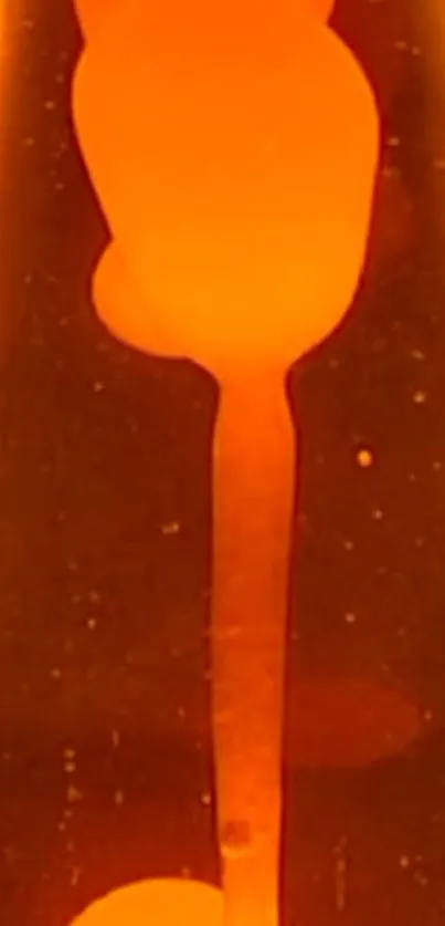 Orange glowing lava lamp with fluid motion on dark background.