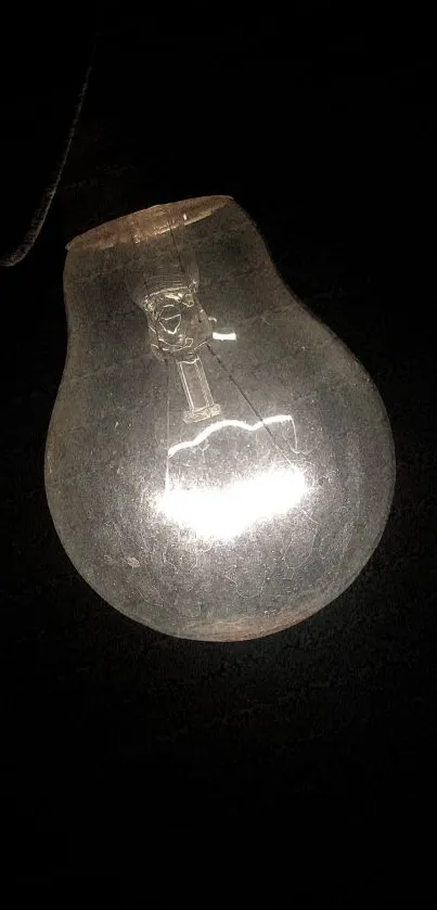 Glowing light bulb against dark backdrop.