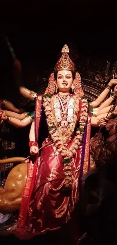 Goddess statue in vibrant red with multiple arms and ornate adornments.