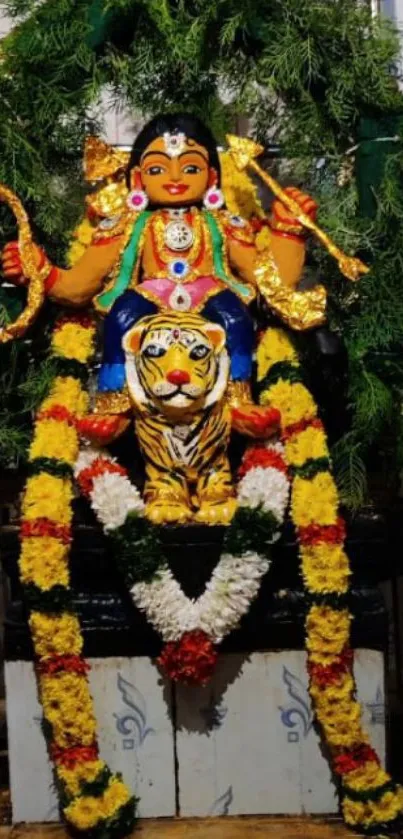 Hindu goddess statue with a tiger and vibrant floral garlands.