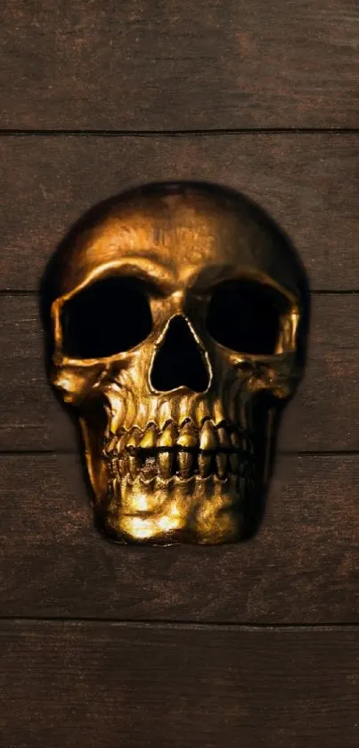 Gold skull on a dark wooden background wallpaper.