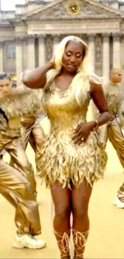 Dancers in golden costumes with architectural backdrop.