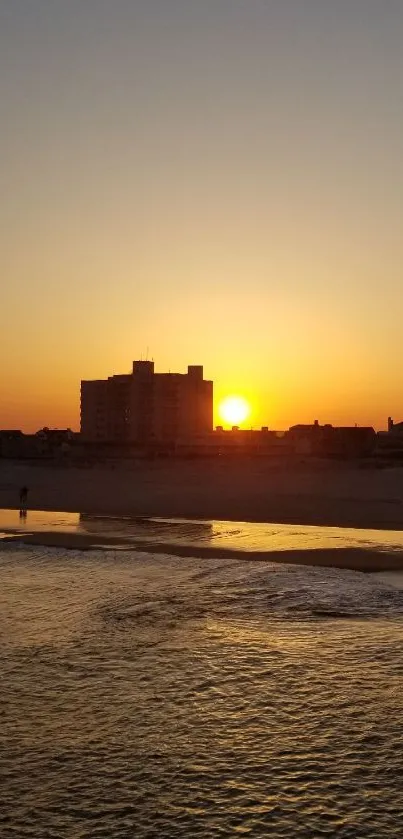 Golden sunset over ocean with beach view.