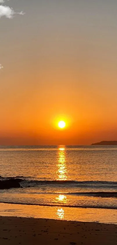 Mobile wallpaper of a golden sunset over a tranquil beach.