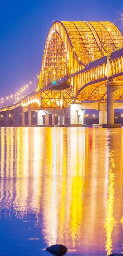 Golden bridge reflecting in water at night.