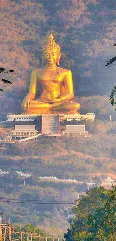 Majestic golden Buddha statue overlooking lush mountains.