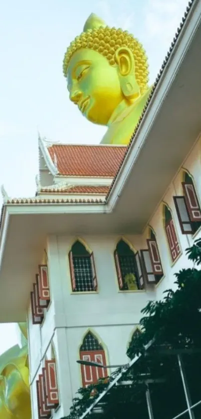 Golden Buddha statue behind temple facade in an urban setting.